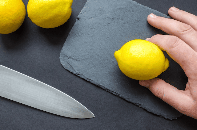 A person about to cut a lemon