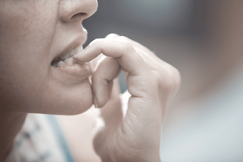 A woman biting her nails