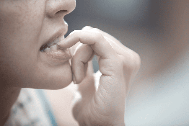 A woman biting her nails